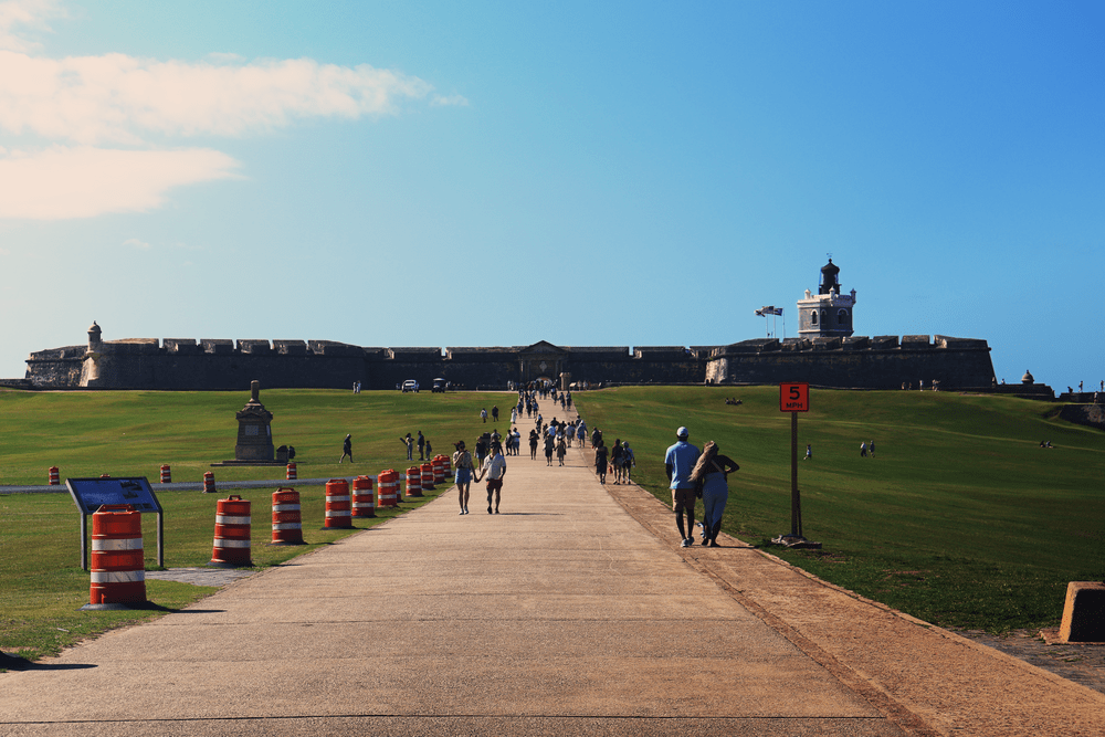 Path leading to Castillo San Felipe del Morro with striped traffic barrels